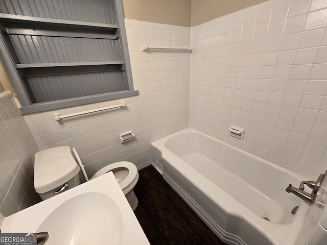 full bathroom with tile walls, sink, toilet, and tiled shower / bath