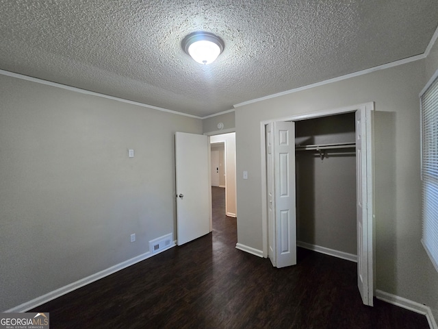 unfurnished bedroom featuring crown molding, dark hardwood / wood-style flooring, a closet, and a textured ceiling