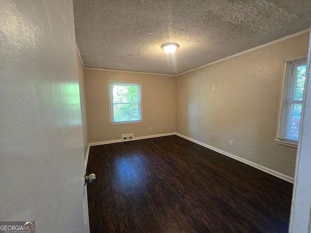 unfurnished room with hardwood / wood-style flooring, ornamental molding, and a textured ceiling