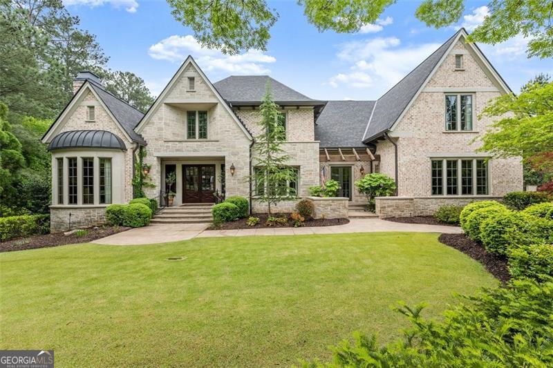 back of house featuring french doors and a lawn