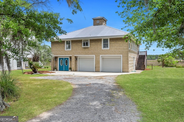 view of front of house with a garage and a front lawn