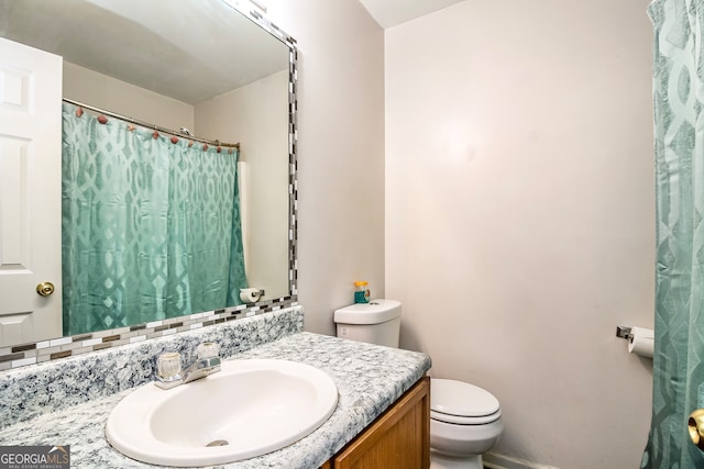 bathroom featuring toilet and vanity with extensive cabinet space