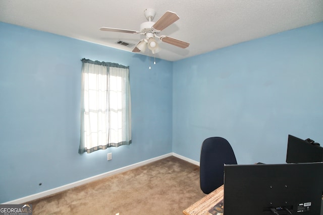 unfurnished office featuring ceiling fan and carpet floors