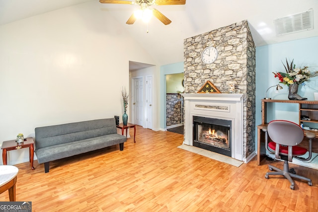 interior space with high vaulted ceiling, light hardwood / wood-style flooring, ceiling fan, and a fireplace