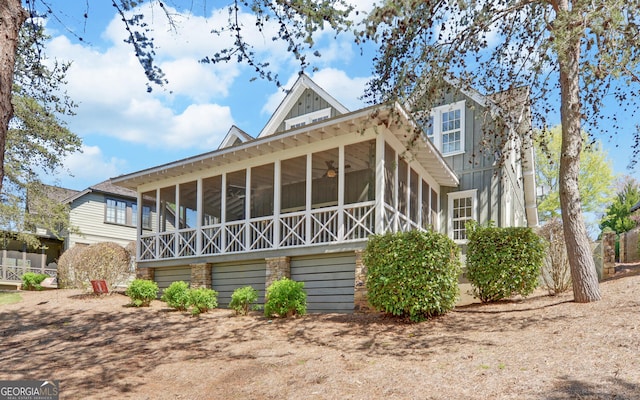 back of property with ceiling fan and a sunroom