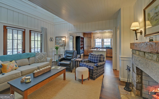 living room featuring wood ceiling, hardwood / wood-style flooring, a wealth of natural light, and a stone fireplace