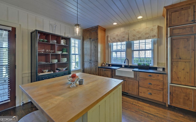 kitchen with sink, butcher block countertops, dark hardwood / wood-style floors, pendant lighting, and wood ceiling