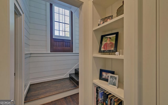 interior space with built in shelves and dark hardwood / wood-style flooring