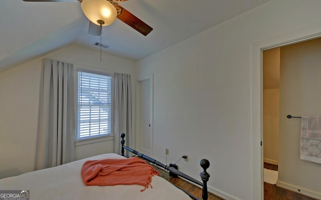 bedroom featuring ceiling fan, dark wood-type flooring, vaulted ceiling, and multiple windows