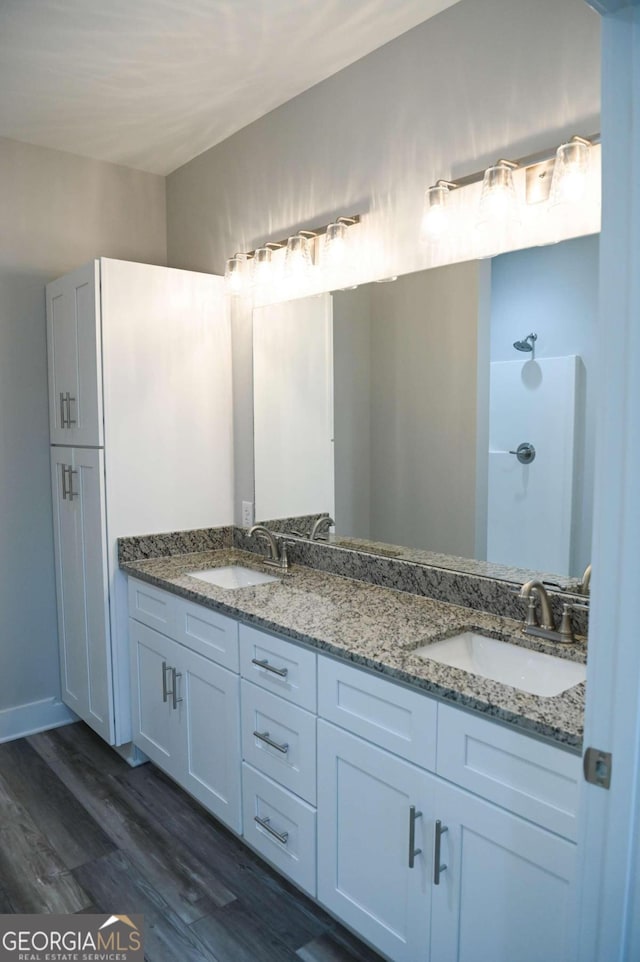 bathroom featuring wood-type flooring, vanity, and walk in shower