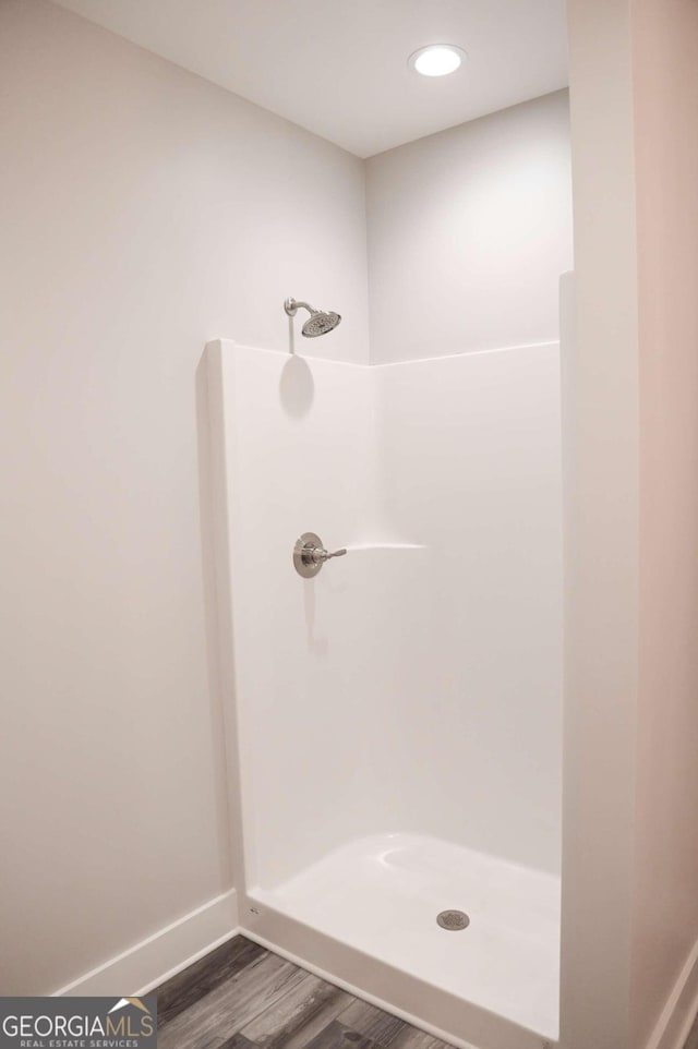 bathroom with a shower and hardwood / wood-style floors