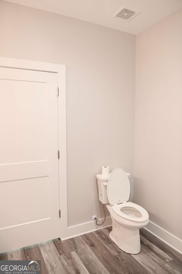 bathroom with hardwood / wood-style floors and toilet