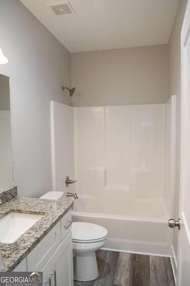 full bathroom with shower / tub combination, vanity, toilet, and hardwood / wood-style flooring