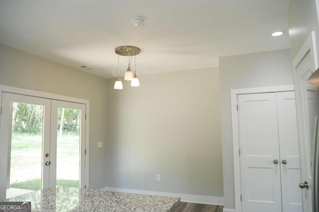 unfurnished dining area featuring wood-type flooring and an inviting chandelier