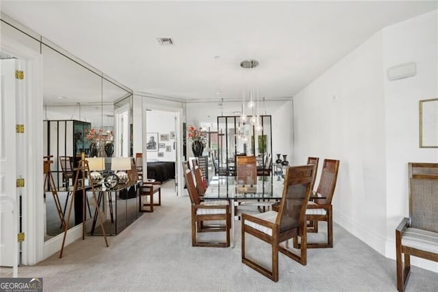 dining room featuring a chandelier and light colored carpet