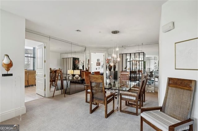 dining area featuring light colored carpet and a notable chandelier