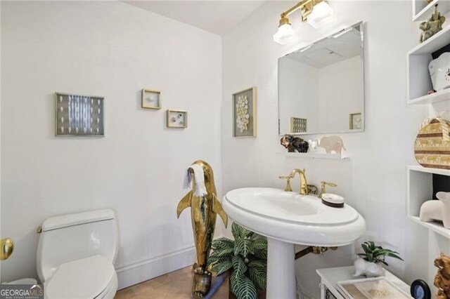 bathroom featuring toilet and tile flooring