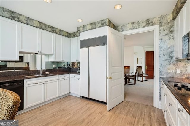 kitchen featuring white cabinets, sink, light hardwood / wood-style flooring, and black appliances