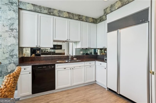 kitchen featuring paneled built in fridge, sink, dishwasher, and white cabinetry