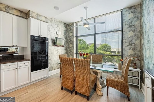 dining room with ceiling fan and light wood-type flooring