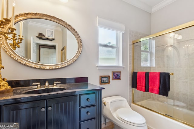 full bathroom with shower / bath combination with glass door, vanity with extensive cabinet space, toilet, and ornamental molding