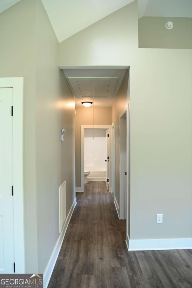 hallway with dark hardwood / wood-style flooring and vaulted ceiling