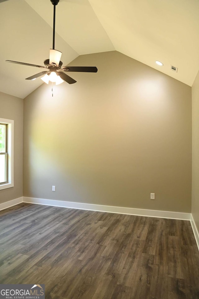 empty room featuring dark hardwood / wood-style flooring, ceiling fan, and vaulted ceiling