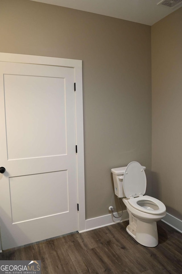 bathroom featuring wood-type flooring and toilet