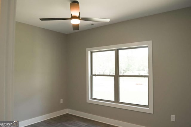 empty room featuring dark wood-type flooring and ceiling fan