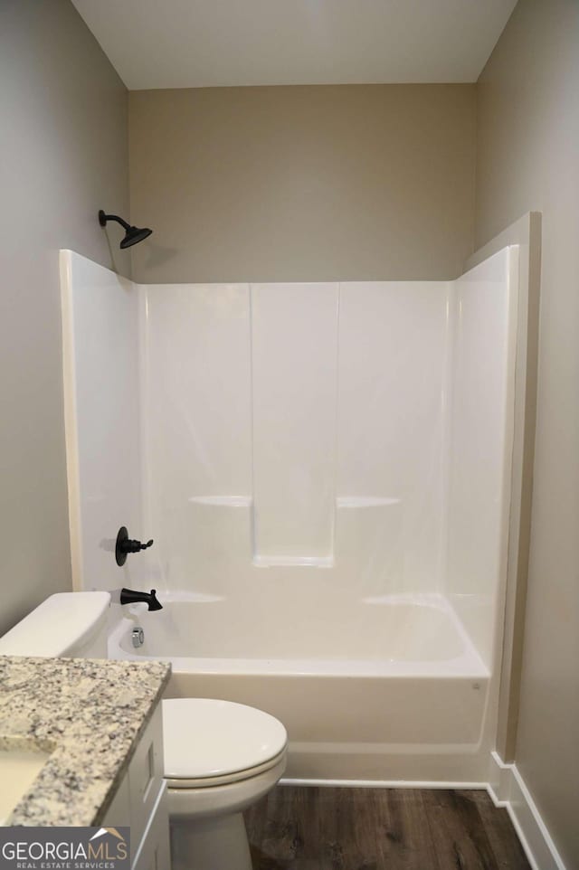 full bathroom featuring shower / washtub combination, vanity, hardwood / wood-style flooring, and toilet