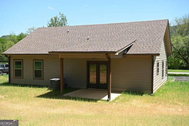 rear view of property with a yard and central AC unit