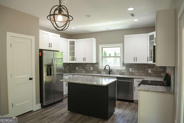 kitchen featuring appliances with stainless steel finishes, a kitchen island, dark wood-type flooring, and white cabinetry