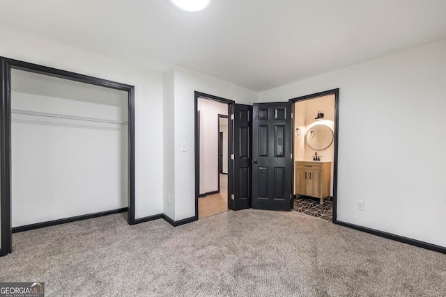 unfurnished bedroom featuring ensuite bath, carpet, and a closet