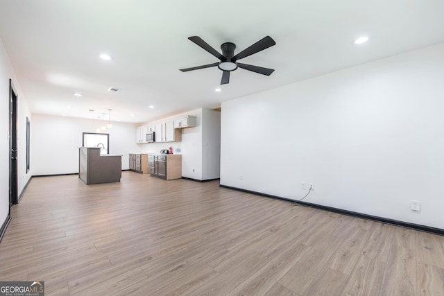 unfurnished living room featuring light hardwood / wood-style floors and ceiling fan