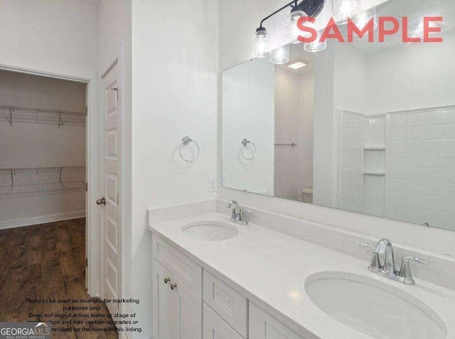 bathroom featuring hardwood / wood-style floors, toilet, and dual vanity