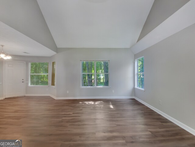 unfurnished room with lofted ceiling, a chandelier, and dark hardwood / wood-style floors