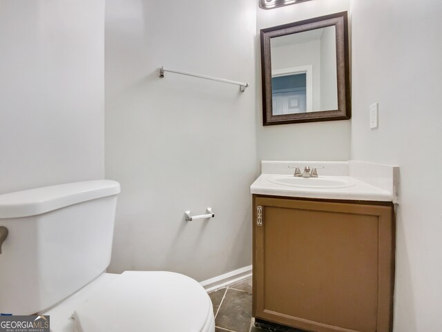 bathroom featuring tile flooring, vanity, and toilet