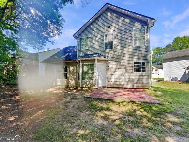 rear view of house with a yard and a patio