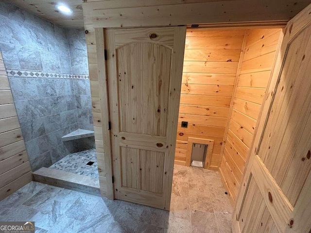 bathroom with wood walls and tile floors