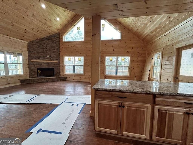 kitchen with high vaulted ceiling, dark hardwood / wood-style floors, wooden ceiling, and a fireplace