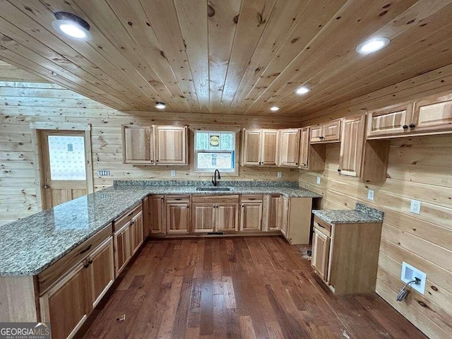 kitchen with wood walls, dark hardwood / wood-style floors, wooden ceiling, sink, and light stone counters