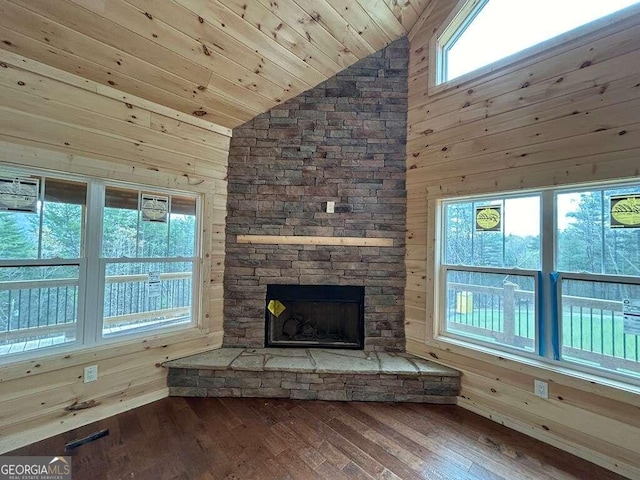 unfurnished living room featuring hardwood / wood-style floors, lofted ceiling, and wood walls