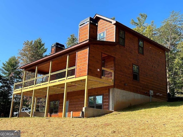 view of property exterior featuring a balcony and a lawn