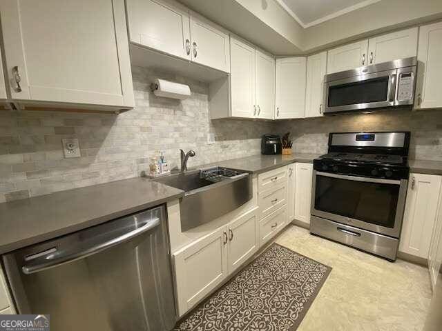 kitchen featuring sink, tasteful backsplash, white cabinetry, and stainless steel appliances