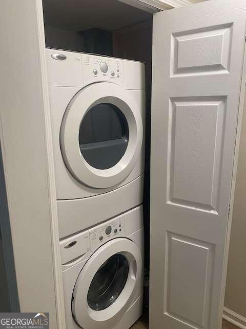 washroom featuring stacked washer / drying machine