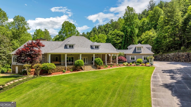 cape cod-style house featuring a front yard and covered porch