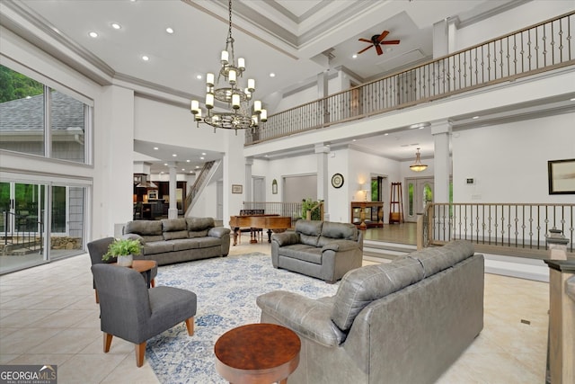 living room featuring a towering ceiling, a wealth of natural light, crown molding, and ceiling fan with notable chandelier