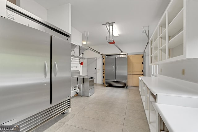 kitchen featuring high end refrigerator, light tile flooring, and stainless steel fridge