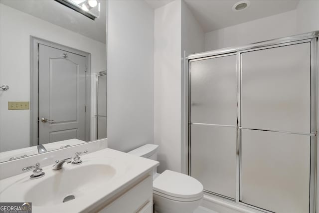 bathroom featuring walk in shower, vanity, and toilet