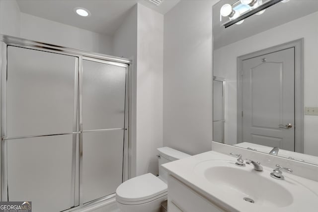 bathroom with walk in shower, vanity, and toilet